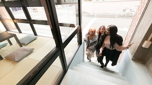A staircase with a view of the street outside. - hostel DEN (Tokyo)
