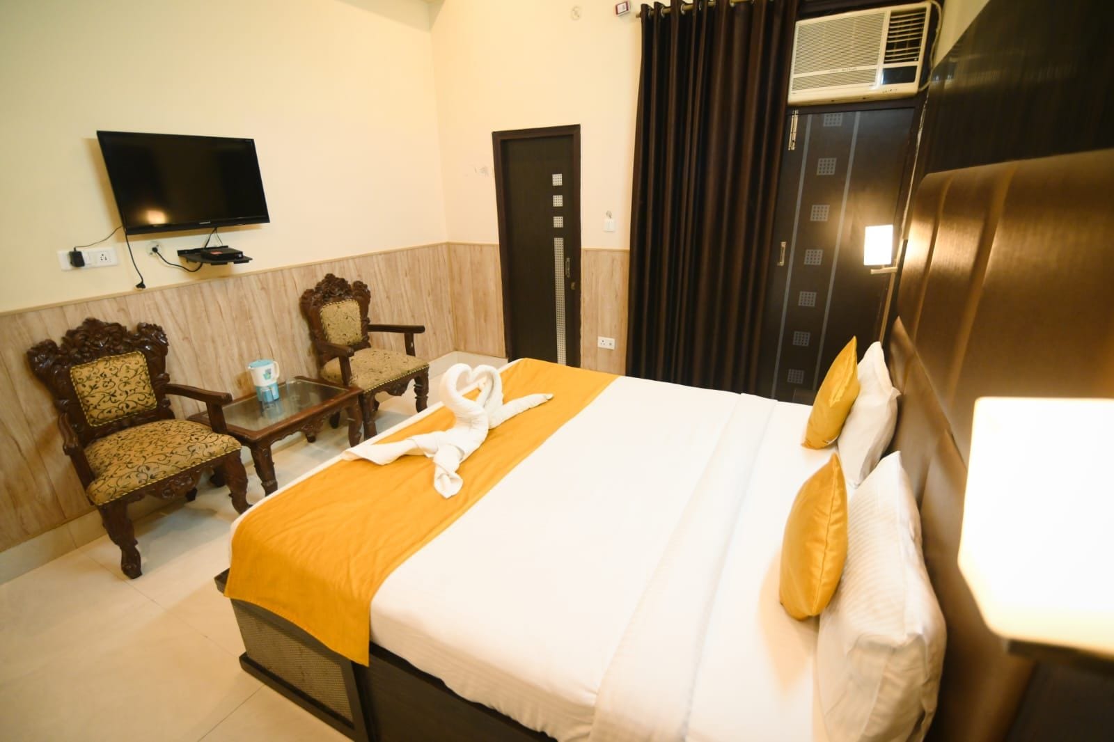 Une chambre d’hôtel avec un lit, une télévision, un bureau et une chaise.