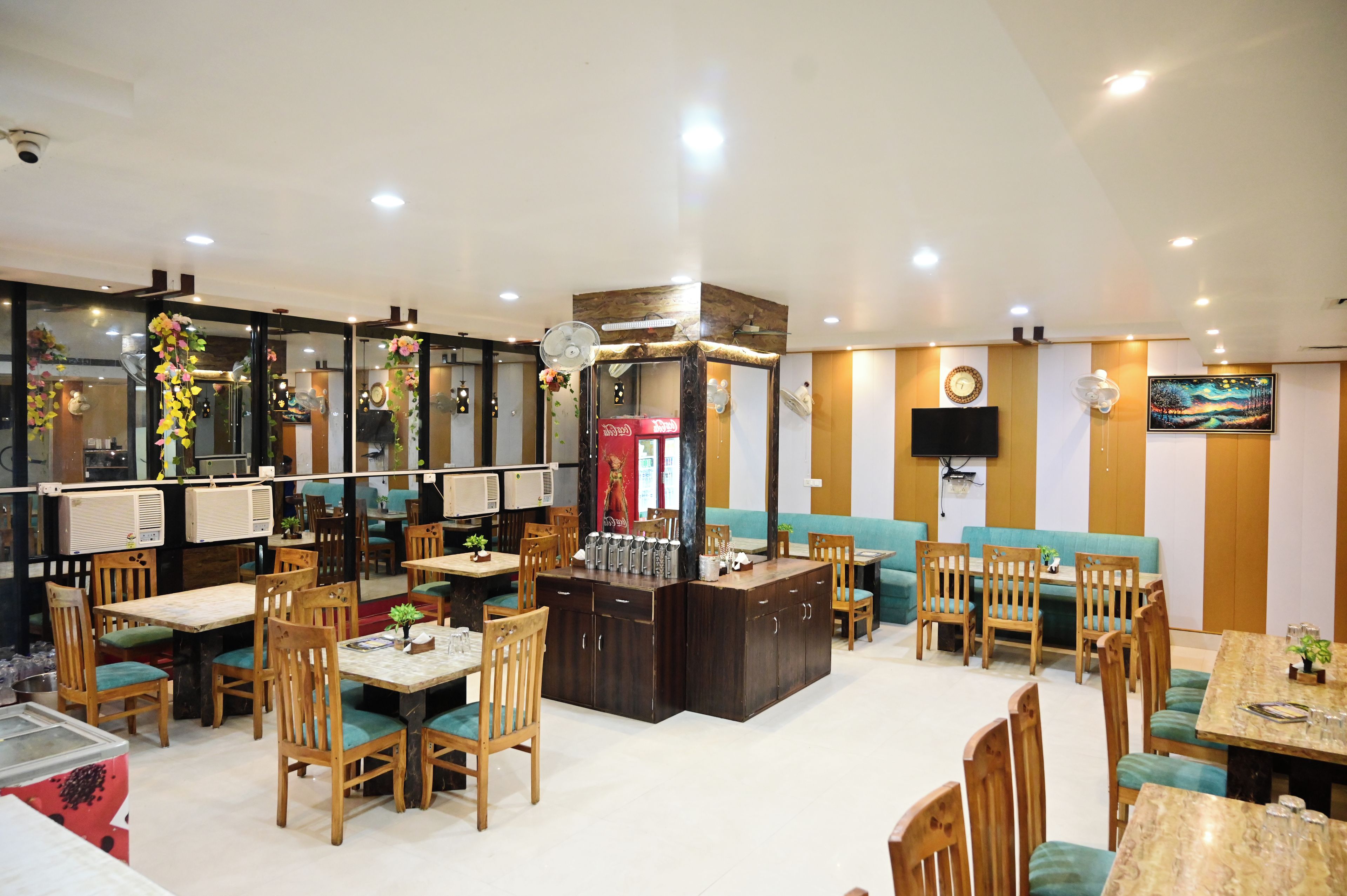 A restaurant interior with multiple seating areas, including booths and tables, and a central bar area.