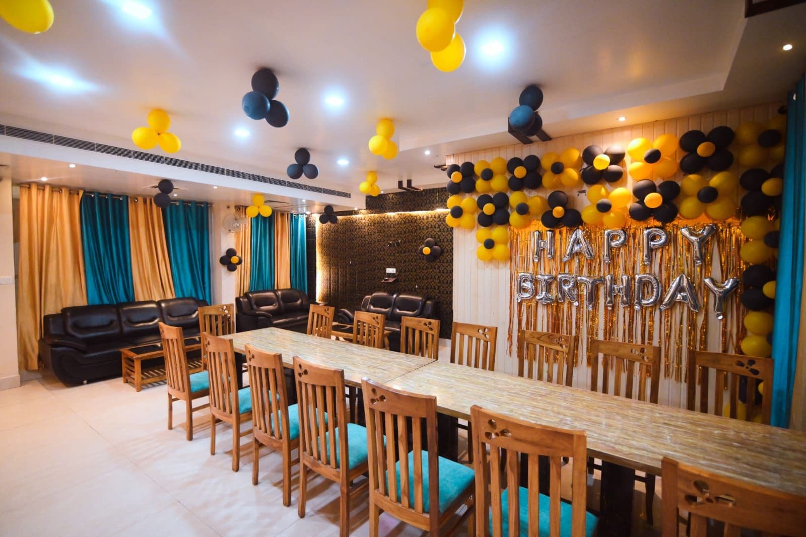 A dining area with a long table and chairs, a patterned wall, and a ceiling with decorative elements.