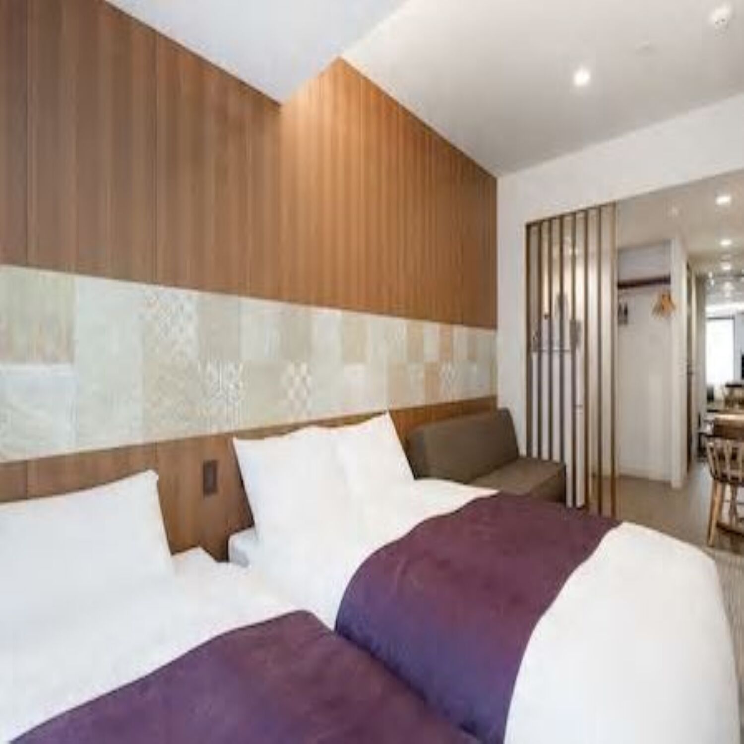 Una habitación de hotel con cama, zona de estar y vista al comedor.