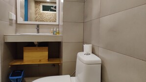 A modern bathroom with a toilet, sink, and mirror. - The Aquzz (Hulhumalé)