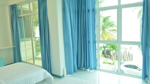 A hotel room with a large window, a bed, and a view of the outdoors. - The Aquzz (Hulhumalé)