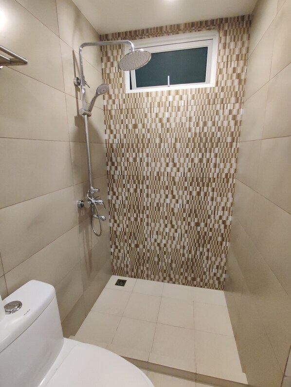 A small, tiled shower area with a window above the shower. - The Aquzz (Hulhumalé)