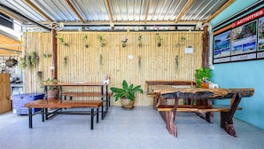 Un intérieur rustique avec des murs en bambou, des meubles en bois et un sol carrelé.