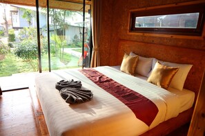 A large bed with a red and white bedspread, two pillows, and a towel on the side. - Baan Check In (Ko Lanta)