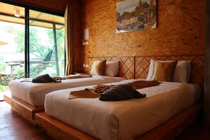 A room with two beds, wooden headboards, a hammock, and a large window with curtains. - Baan Check In (Ko Lanta)