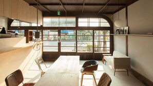 A modern interior with a large window, wooden ceiling, and minimalist furniture. - Sumidanagaya - Hostel (Tokyo)