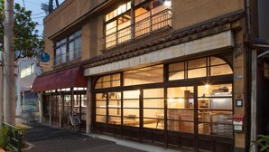 A two-story building with large windows and a bicycle parked outside. - Sumidanagaya - Hostel (Tokyo)