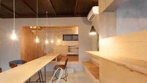 A modern kitchen with a wooden countertop, hanging pendant lights, and a visible stove. - Sumidanagaya - Hostel (Tokyo)
