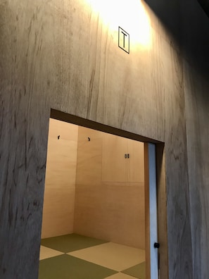 A wooden interior with a checkered floor, a door, and a small window. - Sumidanagaya - Hostel (Tokyo)