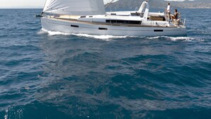 A sailboat with a cabin and deck seating, sailing on a body of water. - Discover Sailing Asia - Hong Kong (Sai Kung)