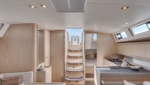 A modern interior with a central sleeping area, a kitchenette, and a dining space. - Discover Sailing Asia - Hong Kong (Sai Kung)