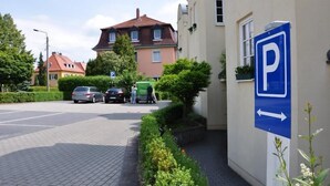 A parking area with a blue sign indicating a parking direction. - Hotel Zwei Länder (Apolda)