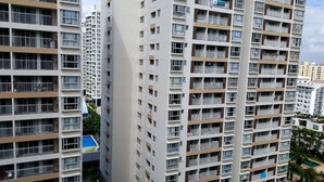A high-rise residential building with multiple balconies, a swimming pool, and a view of surrounding buildings. - Henry Apt Expo Secc Goft SWPool F11th (Ho Chi Minh City)