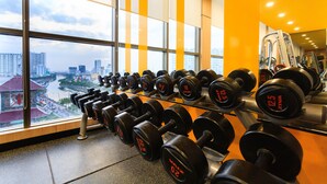 Ein Fitnessstudio mit einem großen Fenster und Blick auf die Stadtlandschaft.