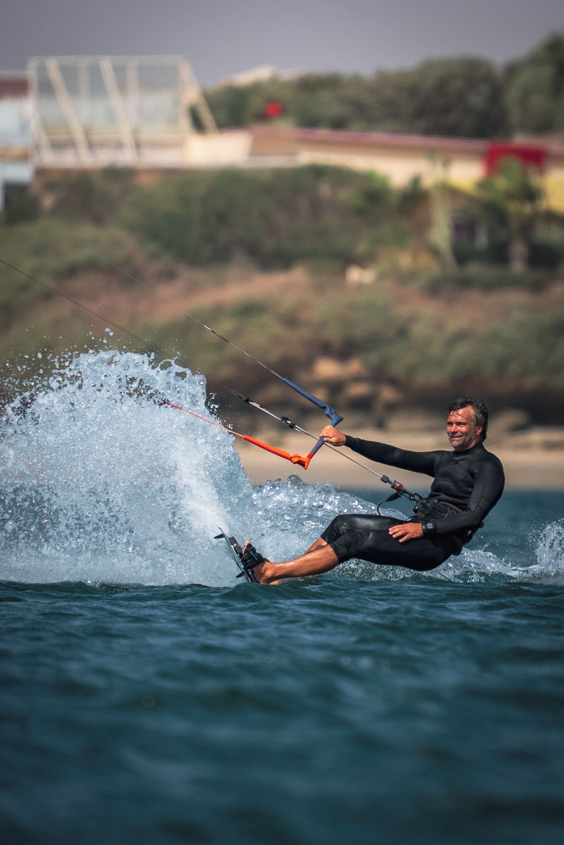 A person windsurfing on a body of water with a clear sky in the background.