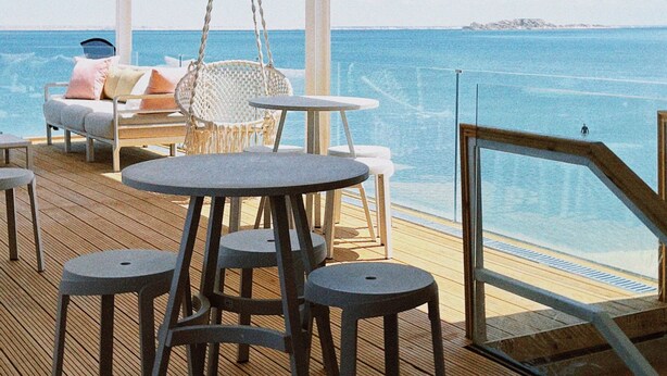 A wooden deck with a hanging chair, a sofa with cushions, and a small round table. - Pk 25 (Dakhla)