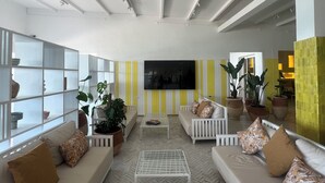 A modern living room with white sofas, a coffee table, and potted plants. - Pk 25 (Dakhla)