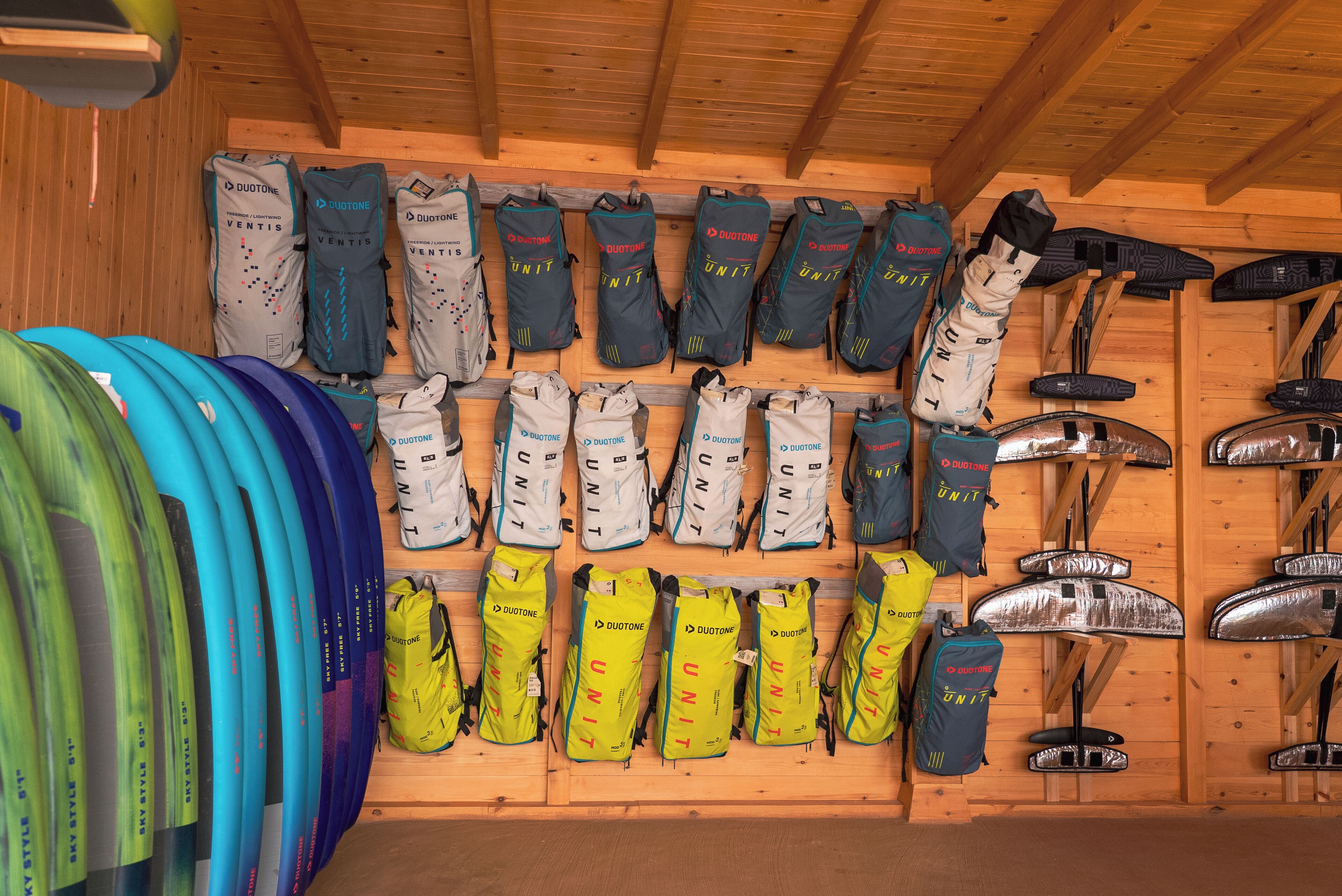 Un cuarto de almacenamiento con varias bolsas y tablas de surf.