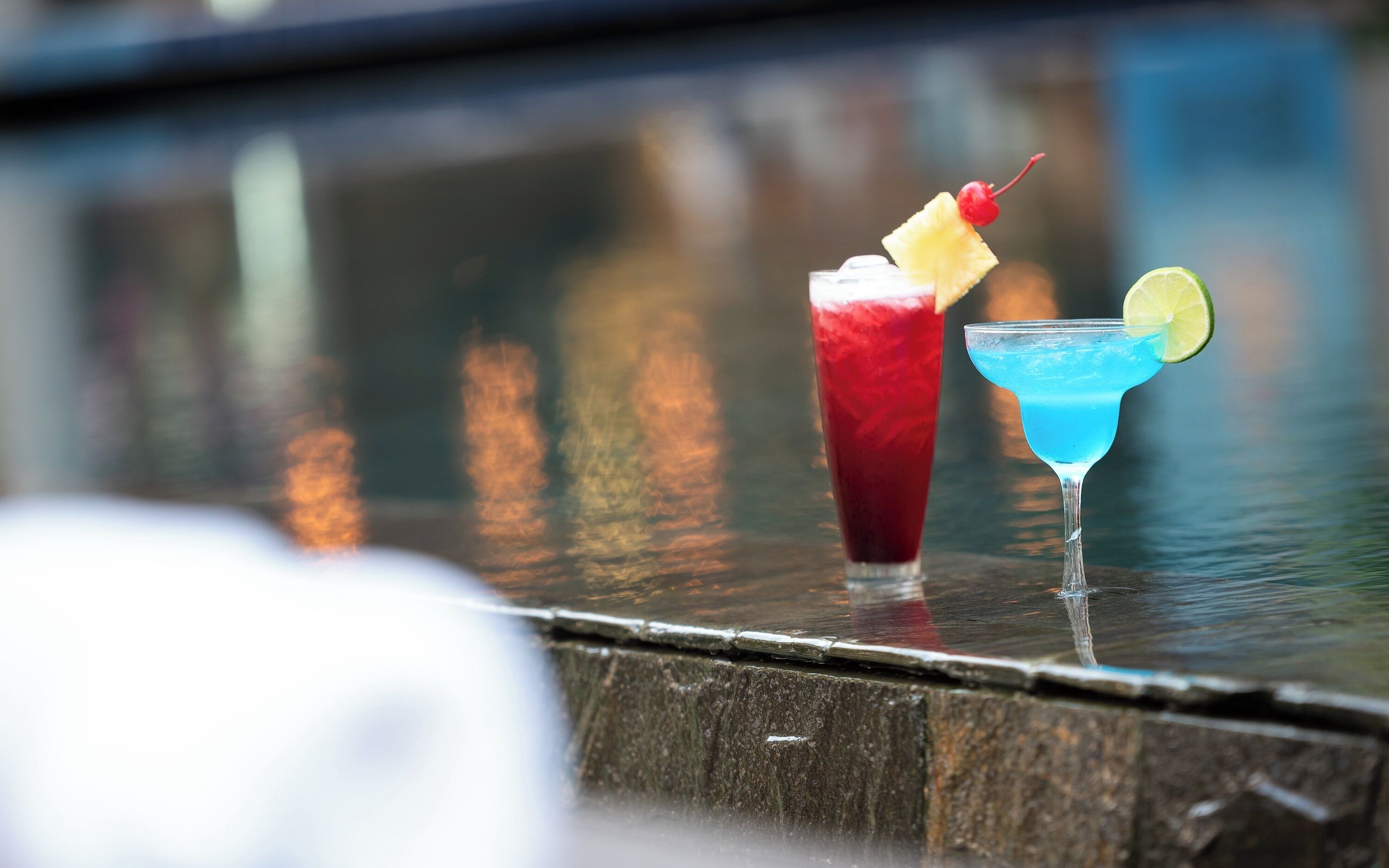 Two cocktails on a bar counter.