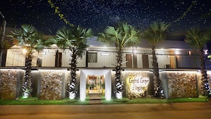 Un hotel con fachada de piedra, palmeras y un letrero que dice "Central Corner d'Angers".