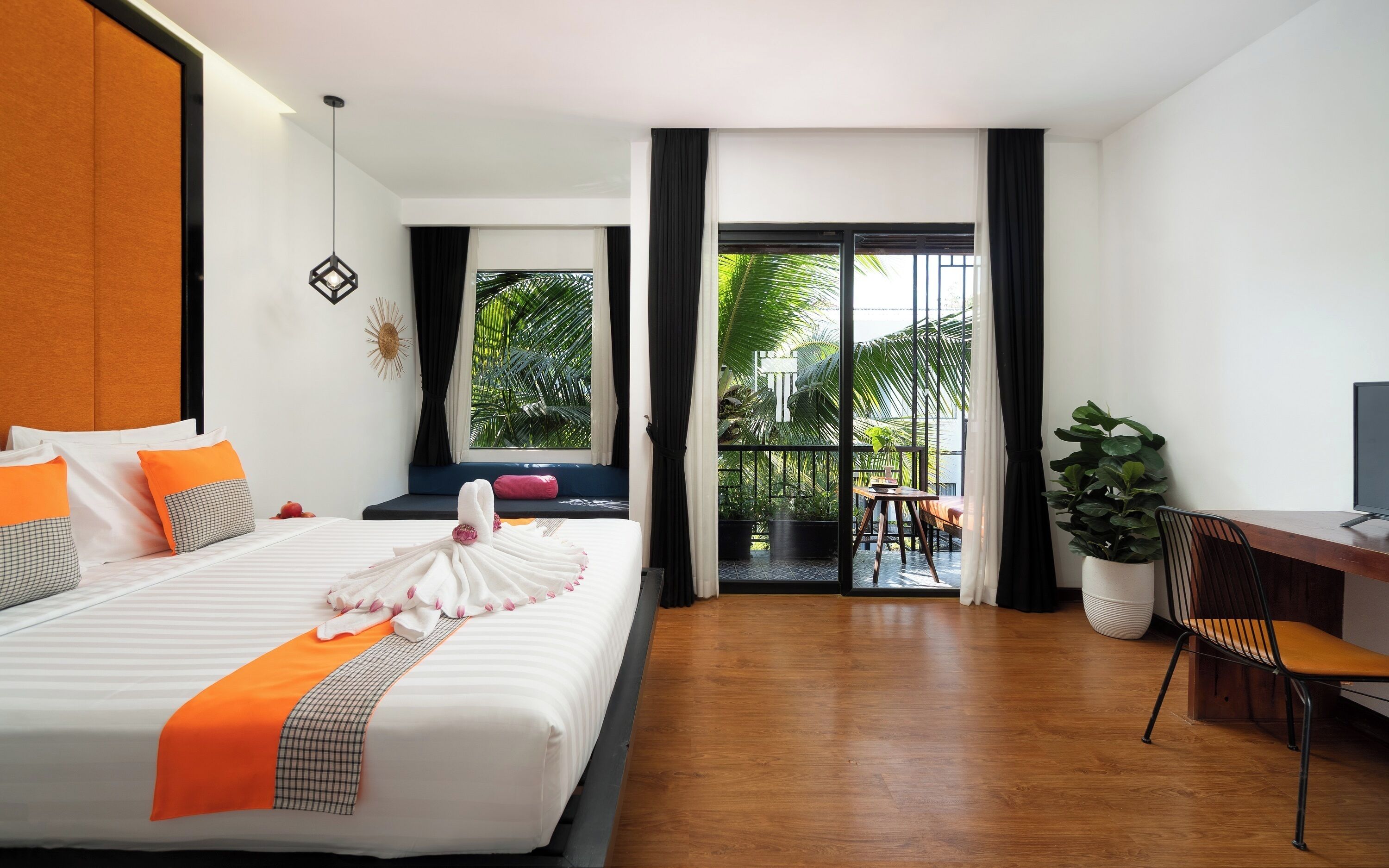 A hotel room with a large bed, a desk, a chair, and a view of the outdoors.