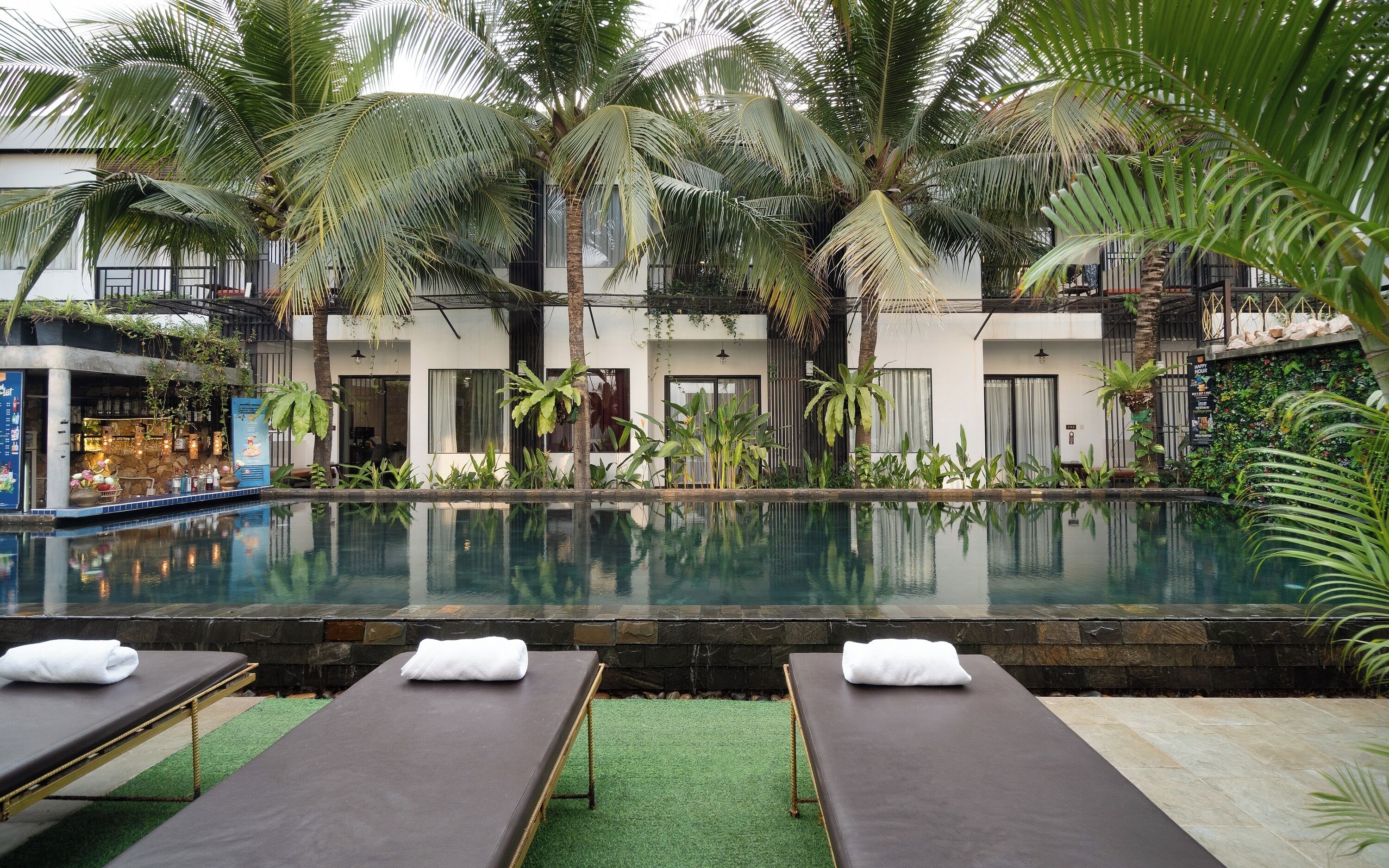 A pool area with lounge chairs and a bar.