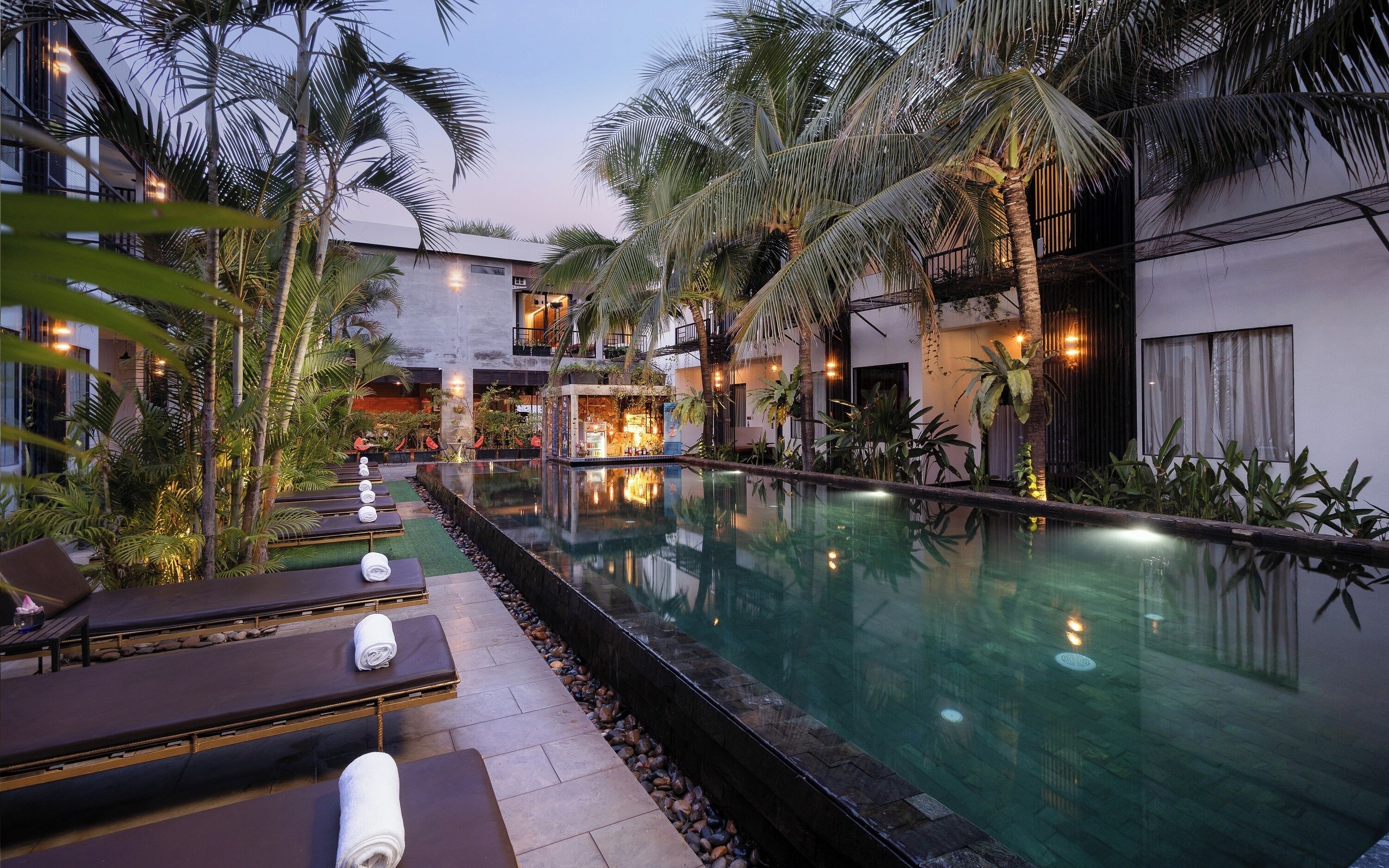 A pool area with lounge chairs and a bar.