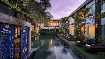 Una piscina al aire libre, sombrillas, sillones reclinables de piscina