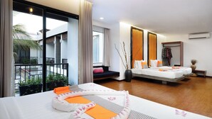 Habitación de hotel con una cama grande, una cama más pequeña, un balcón con vistas y una zona de estar también con vistas.