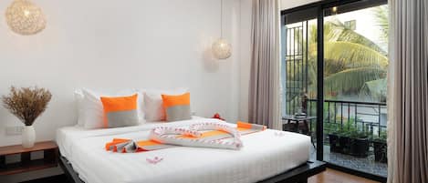 Un dormitorio moderno con cama, mesitas de noche y vistas a un balcón con plantas.