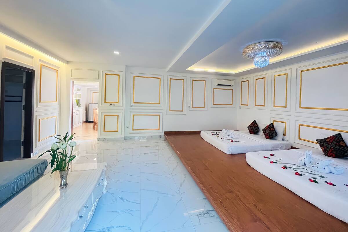 A spacious lobby with a marble floor, a wooden bench, and a reception area.