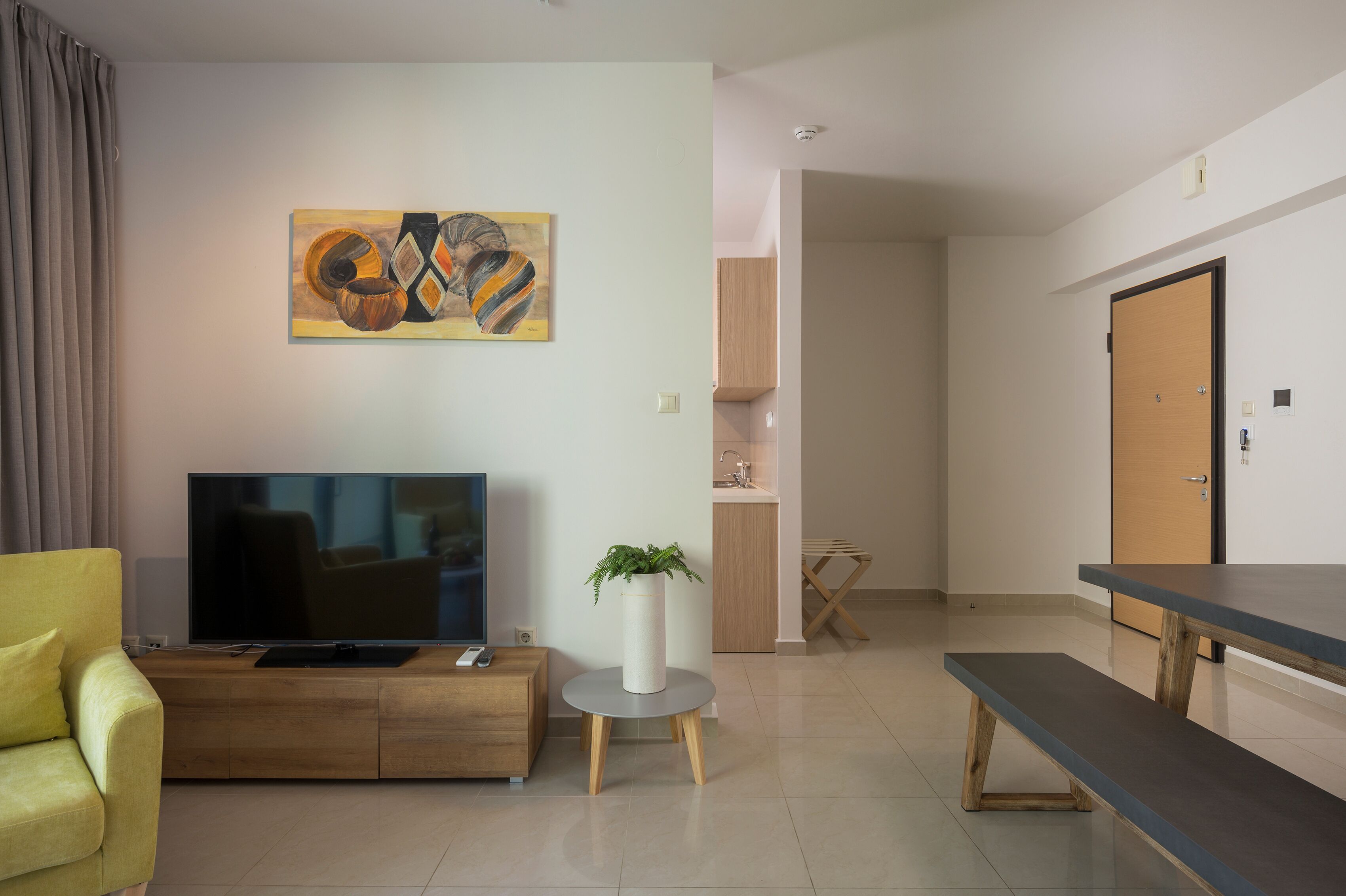 En moderne stue med fjernsyn, sofa, sofabord og spisebord.