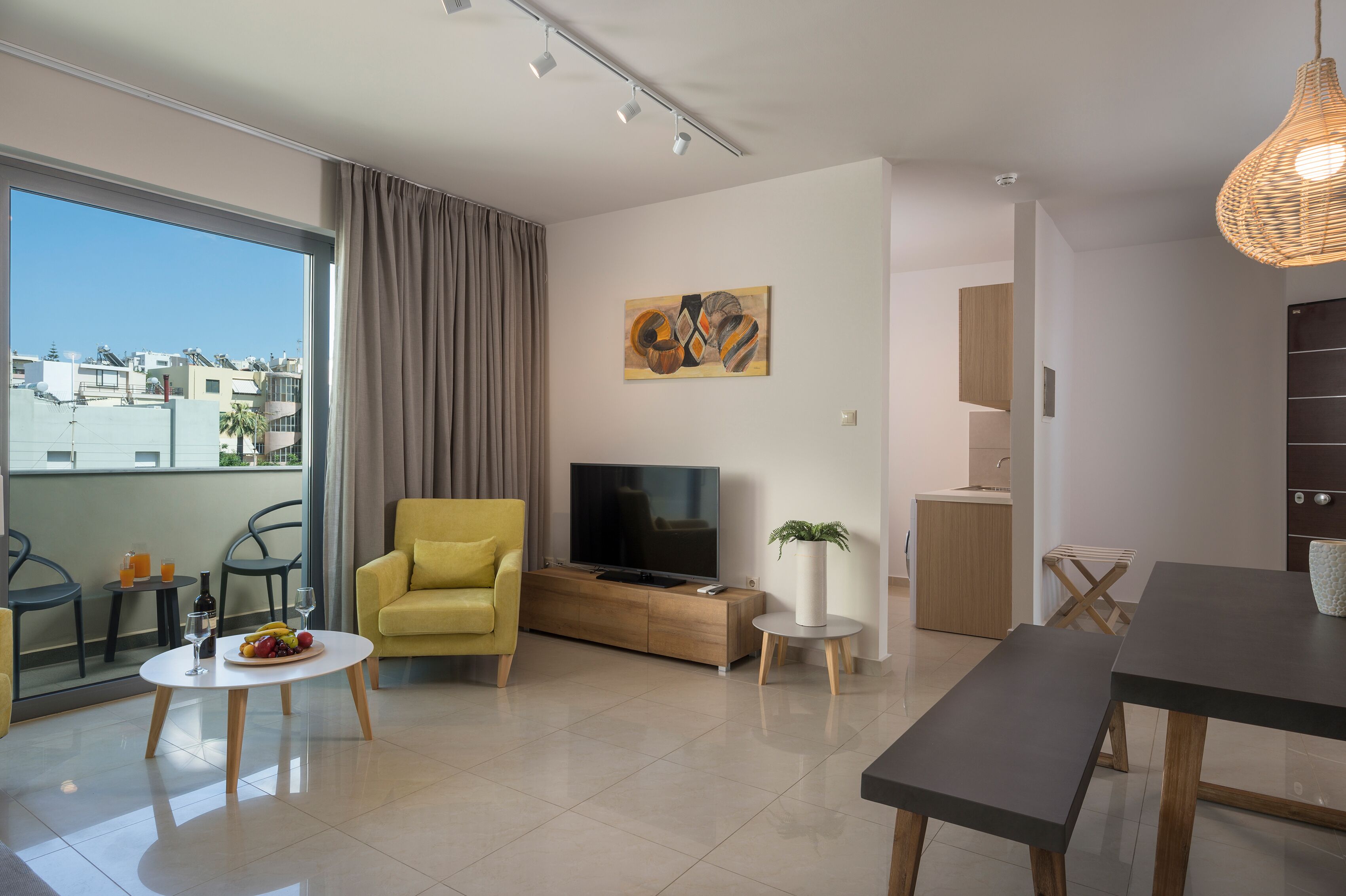 Una sala de estar moderna con sofá, televisión y comedor.