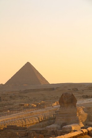 A pyramid and sphinx in a desert setting.