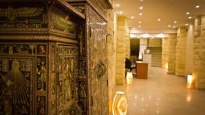 A lobby with a decorative wall featuring ancient Egyptian hieroglyphs and a reception desk. - Pyramids Valley (Giza)