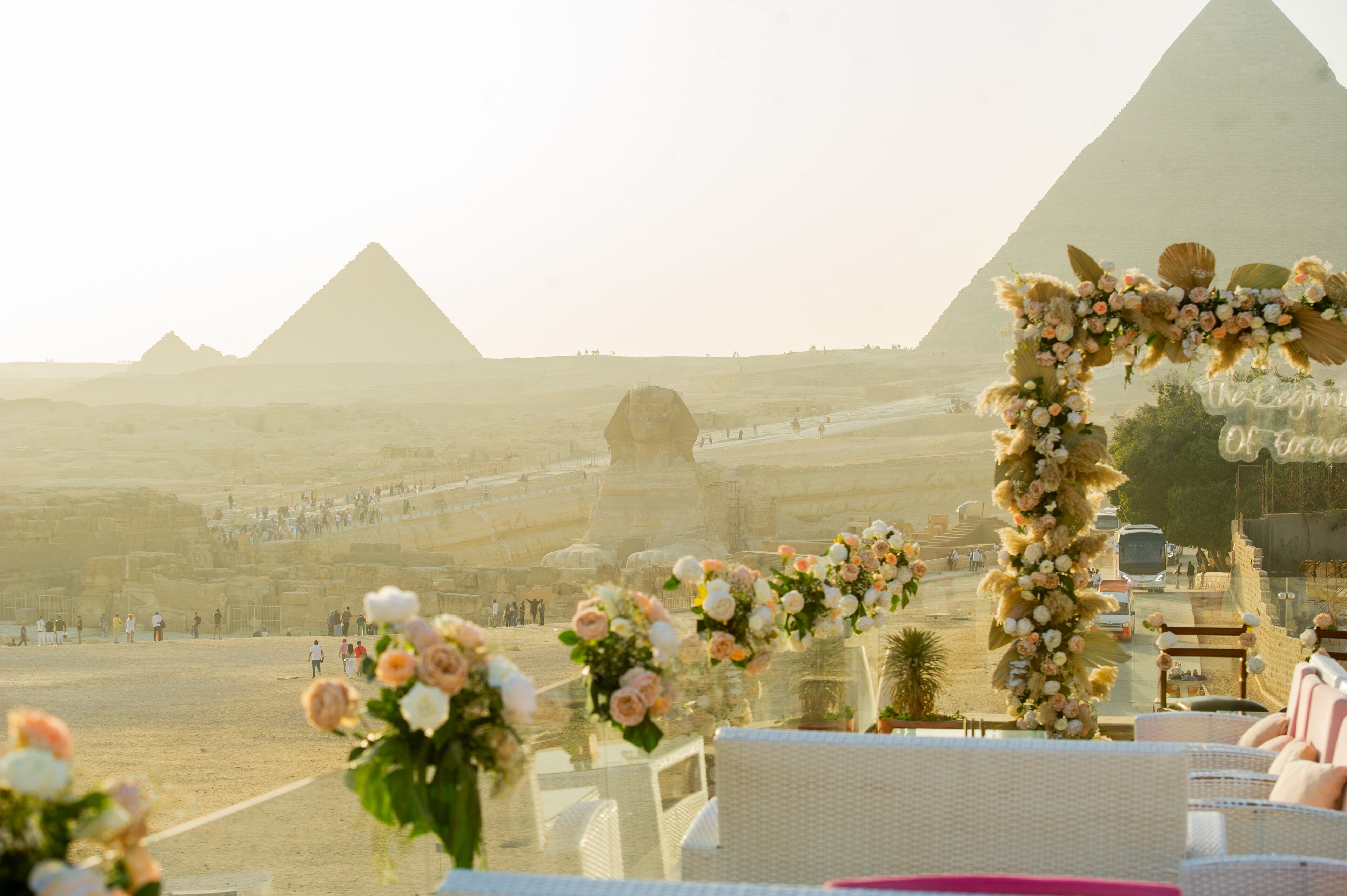 Una ceremonia de boda con un arco floral y vistas a las pirámides.