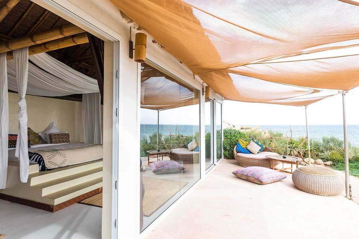 Ein Schlafzimmer mit Himmelbett und Balkon mit Sitzgelegenheit.