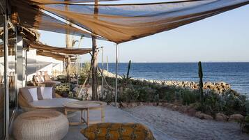 Relax in a shaded seating area overlooking the ocean with a scenic view.