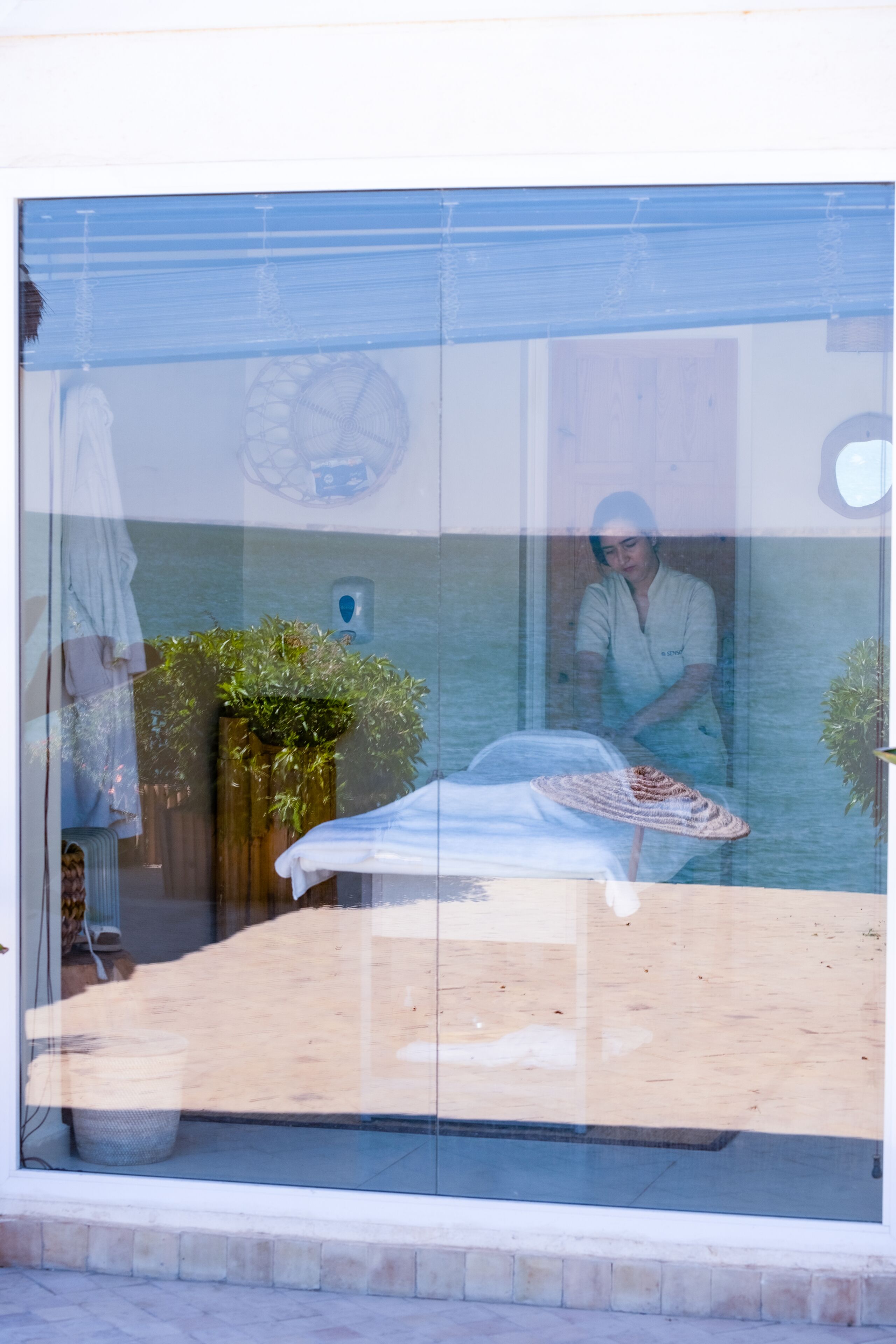 A room with a bed, a window, and a plant.
