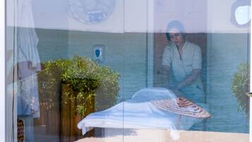 A room with a bed, a window, and a plant.