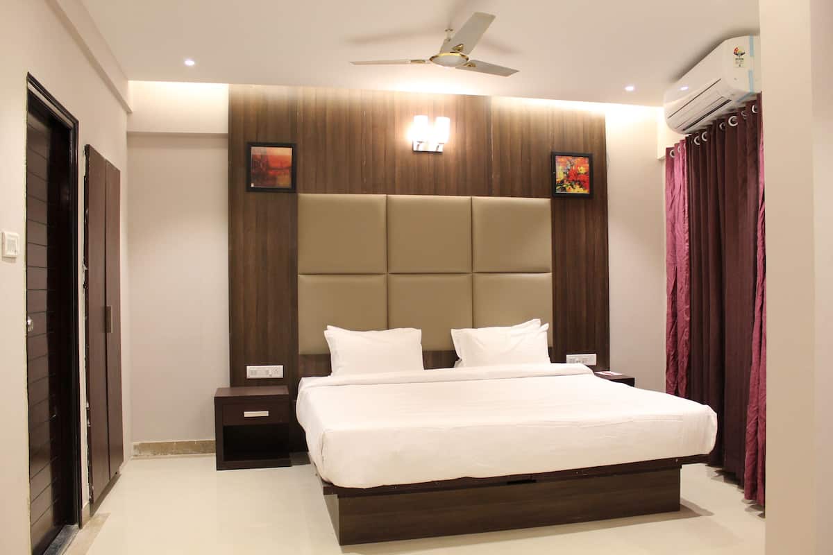 Une chambre moderne avec un grand lit, un ventilateur de plafond et un appareil de climatisation.