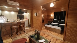 Ein kleines Zimmer mit Küchenzeile, einem Bett und einer kleinen Sitzecke.