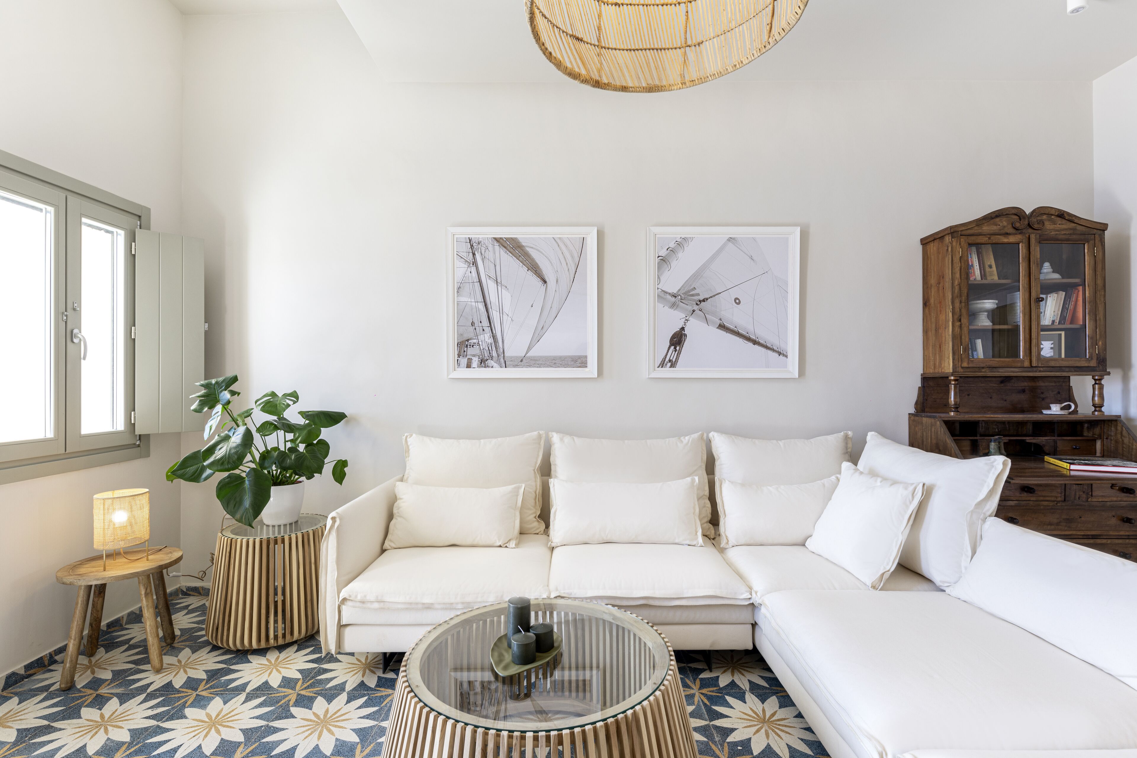 Un salon moderne avec un canapé blanc, une table basse en verre et un meuble en bois.