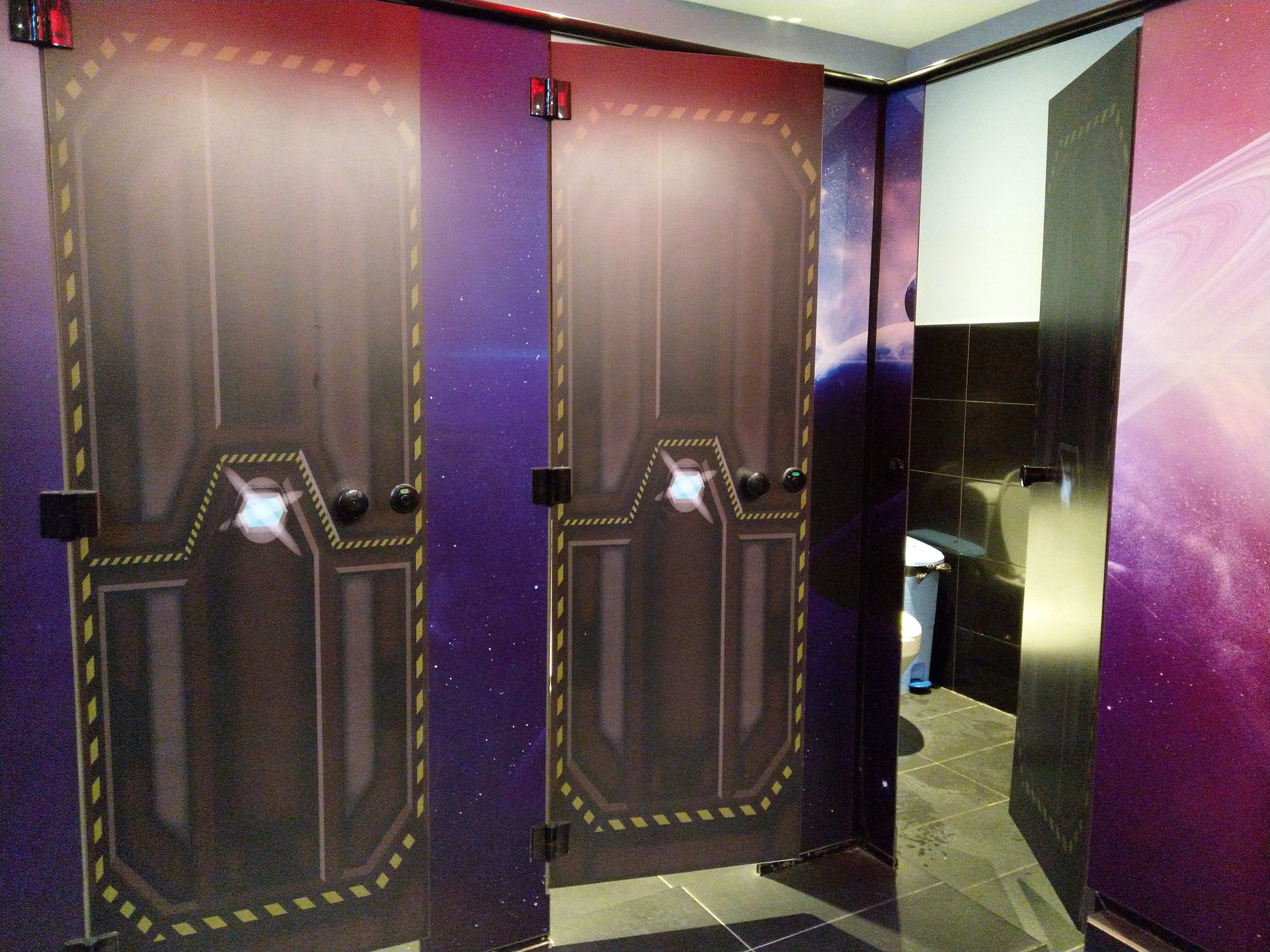 A hallway with two doors featuring a starry night design, leading to a bathroom area with a sink and mirror.