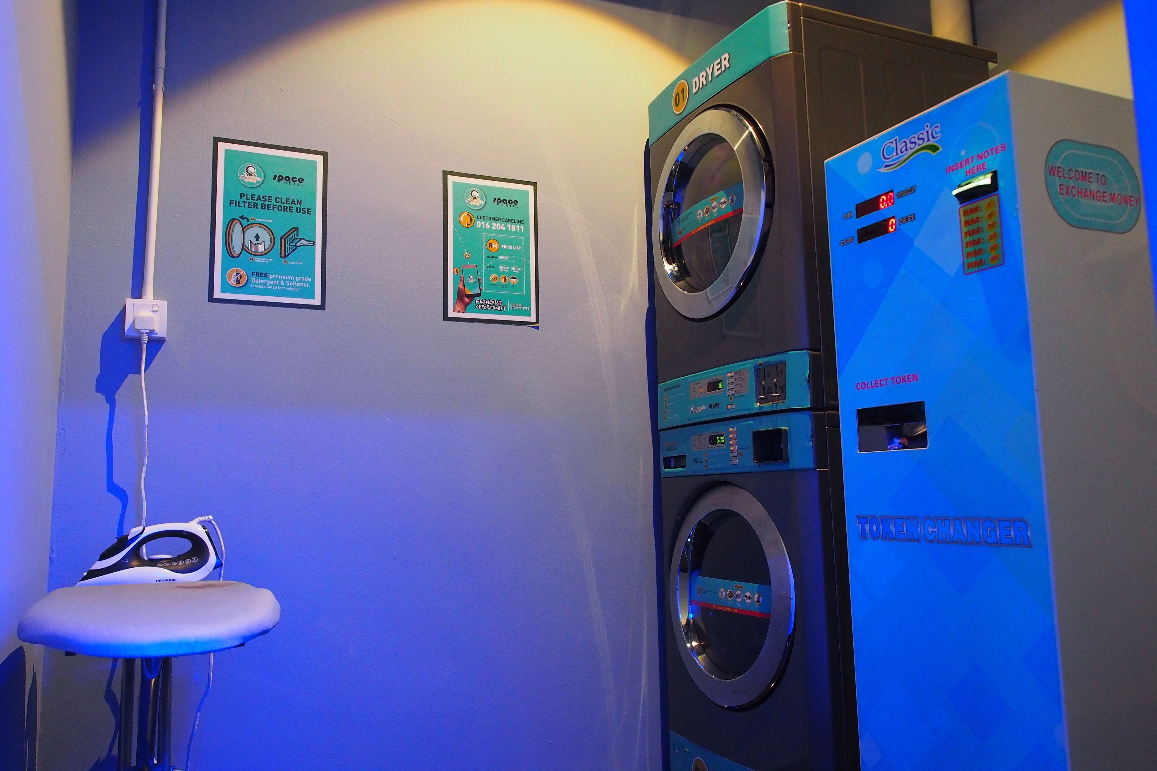A laundry facility with a washing machine, a dryer, and a coin-operated changing station.