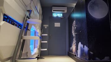 A hallway with a neon sign reading "KELUAR," an air conditioning unit, and a wall with a celestial-themed mural.