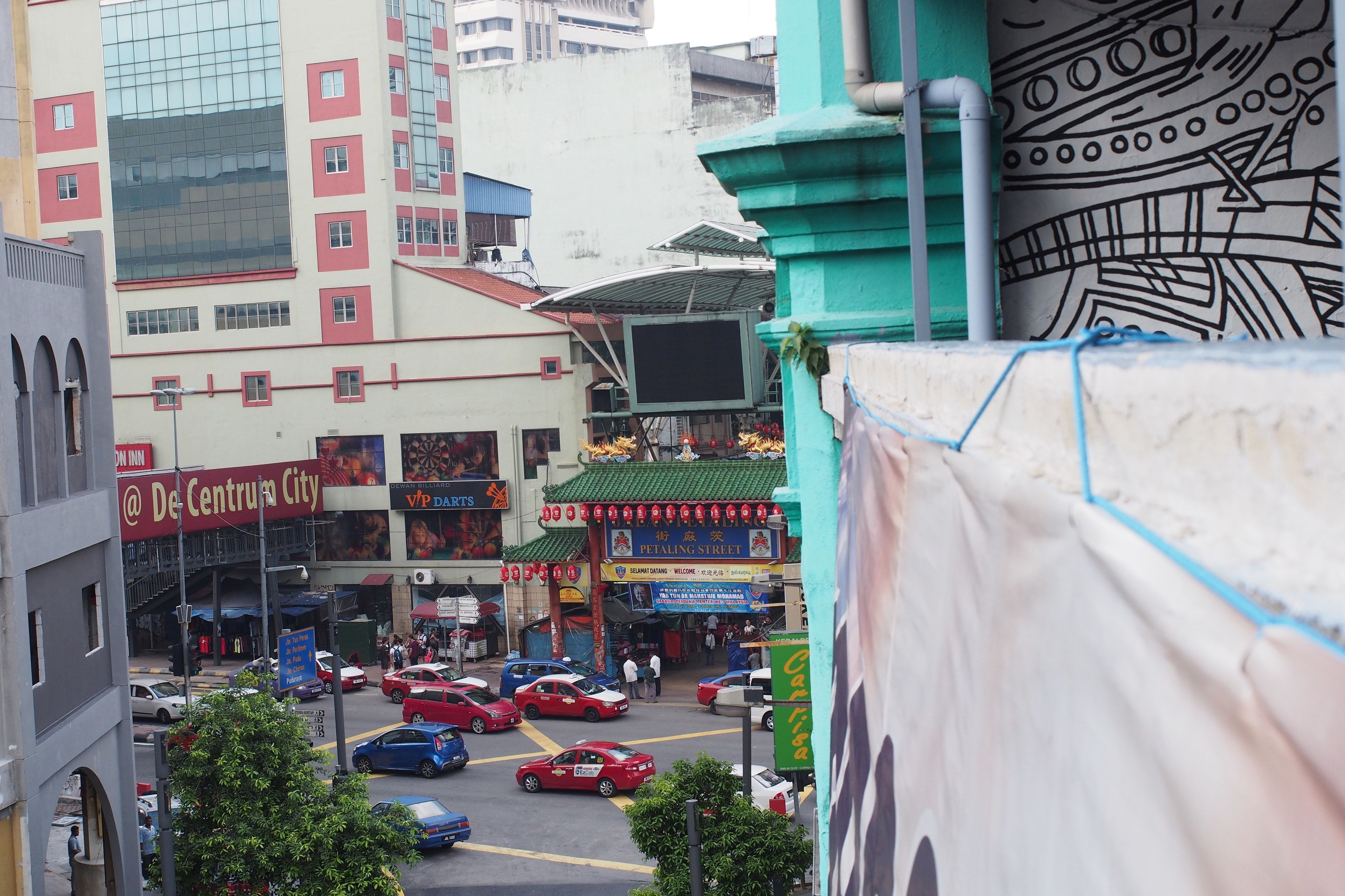 A busy street with a large building featuring a sign for 'De Centro City'.