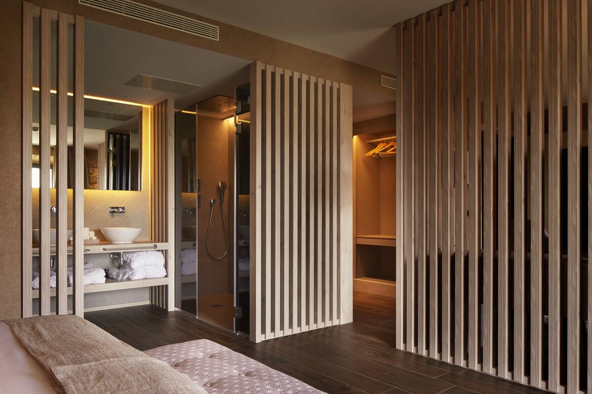 A modern bathroom with a large mirror, a sink, and a shower.